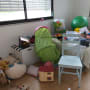 חדר מבולגן עם צעצועים, כדור ירוק, כיסא ומיטה