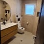 Bathroom with modern fixtures and beige tiles.
