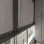 סוככים אפורים מותקנים על חלונות זכוכית במרפסת