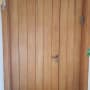 Wooden door with vertical panels and metal handle