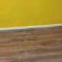 רצפת פרקט עץ חום עם קיר צהוב