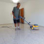אדם מנקה רצפה עם מכונת פוליש חשמלית