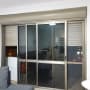 Sliding glass doors with metal shutters partially closed