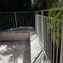 מעקה מתכת לבן על מרפסת עם צללים