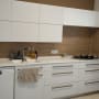 מטבח משופץ עם ארונות לבנים וכיריים חדשות