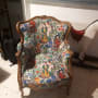כורסה מרופדת בבד צבעוני עם דמויות ופרחים