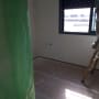 חדר עם סולם, יריעת פלסטיק ירוקה, קיר צבוע חלקית