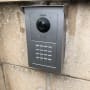 אינטרקום מתכת עם מצלמה ומקשים על קיר בטון