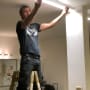 Electrician working on ceiling light fixture