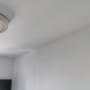 קיר ותקרה צבועים בלבן עם מנורה עגולה