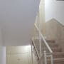 קיר מדרגות צבוע בלבן עם מעקה מתכת