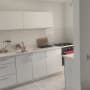 מטבח מודרני עם ארונות לבנים, כיור וכיריים