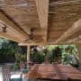 פרגולה מעץ עם שולחן וכיסאות בגינה