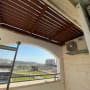 פרגולה מעץ חום מותקנת במרפסת