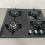 כיריים גז שחורות עם ארבעה מבערים וכפתורי שליטה כסופים