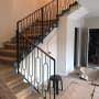 מעקה מתכת שחור עם עיטורים גיאומטריים במדרגות