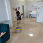 אדם מנקה רצפה עם מכונת פוליש חשמלית