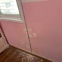 קיר ורוד מתקלף עם סימני רטיבות