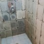 שיפוץ מקלחת עם קירות חשופים וברז מותקן