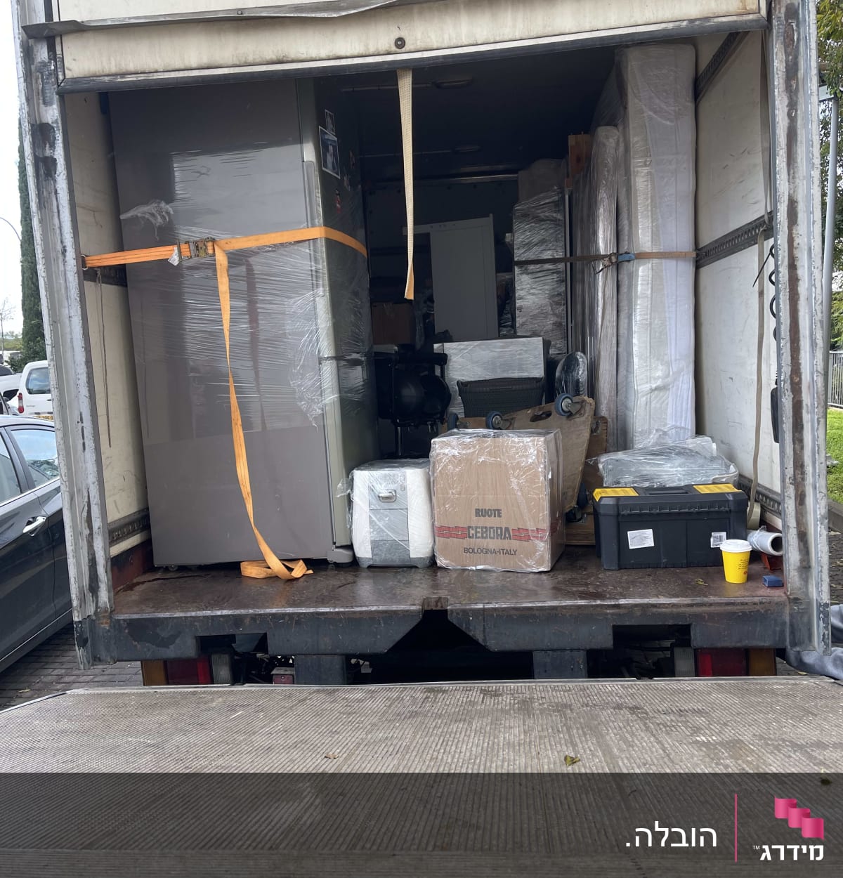 משאית הובלה עם רהיטים וארגזים קשורים