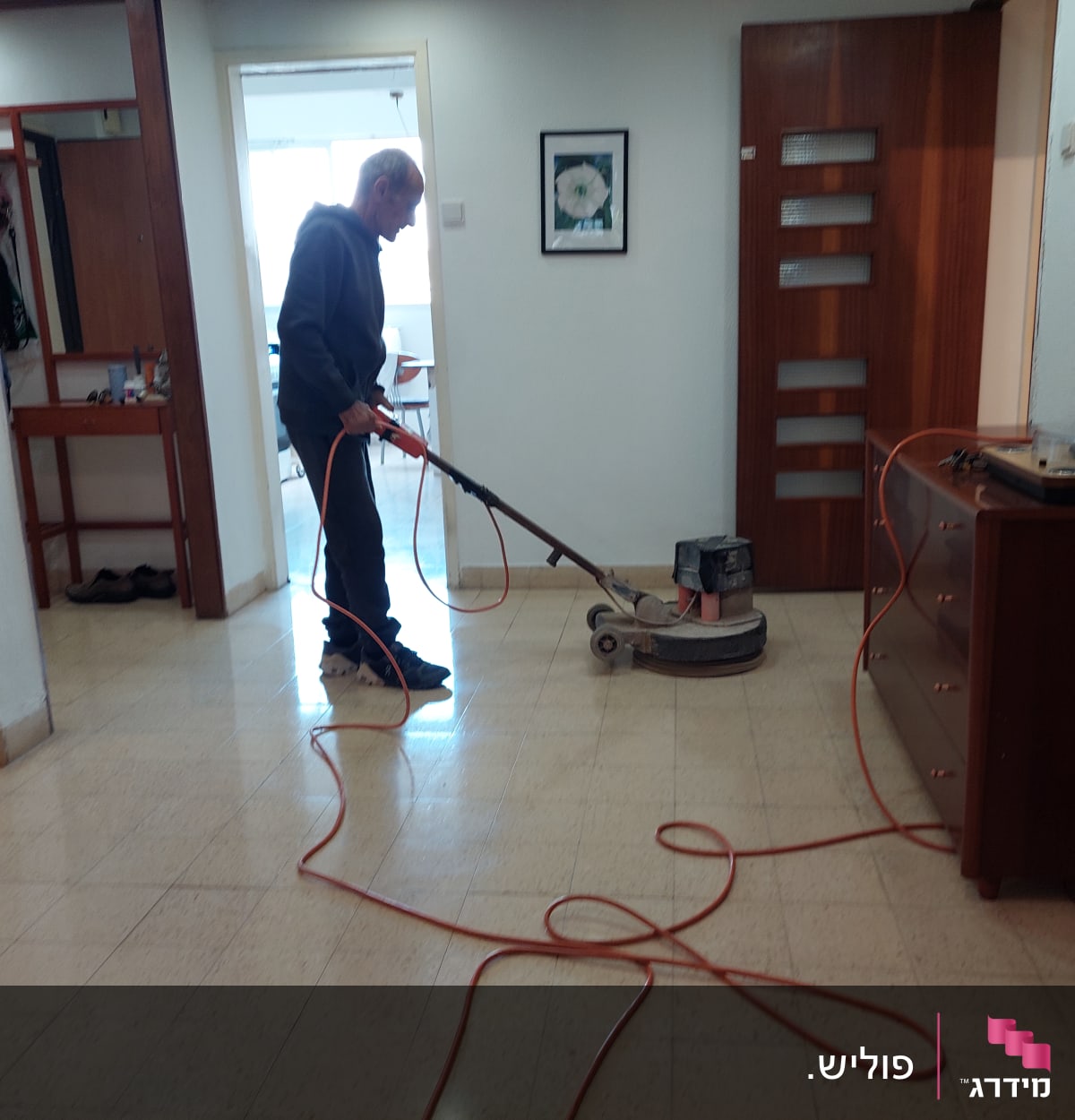 אדם מנקה רצפה עם מכונת פוליש חשמלית
