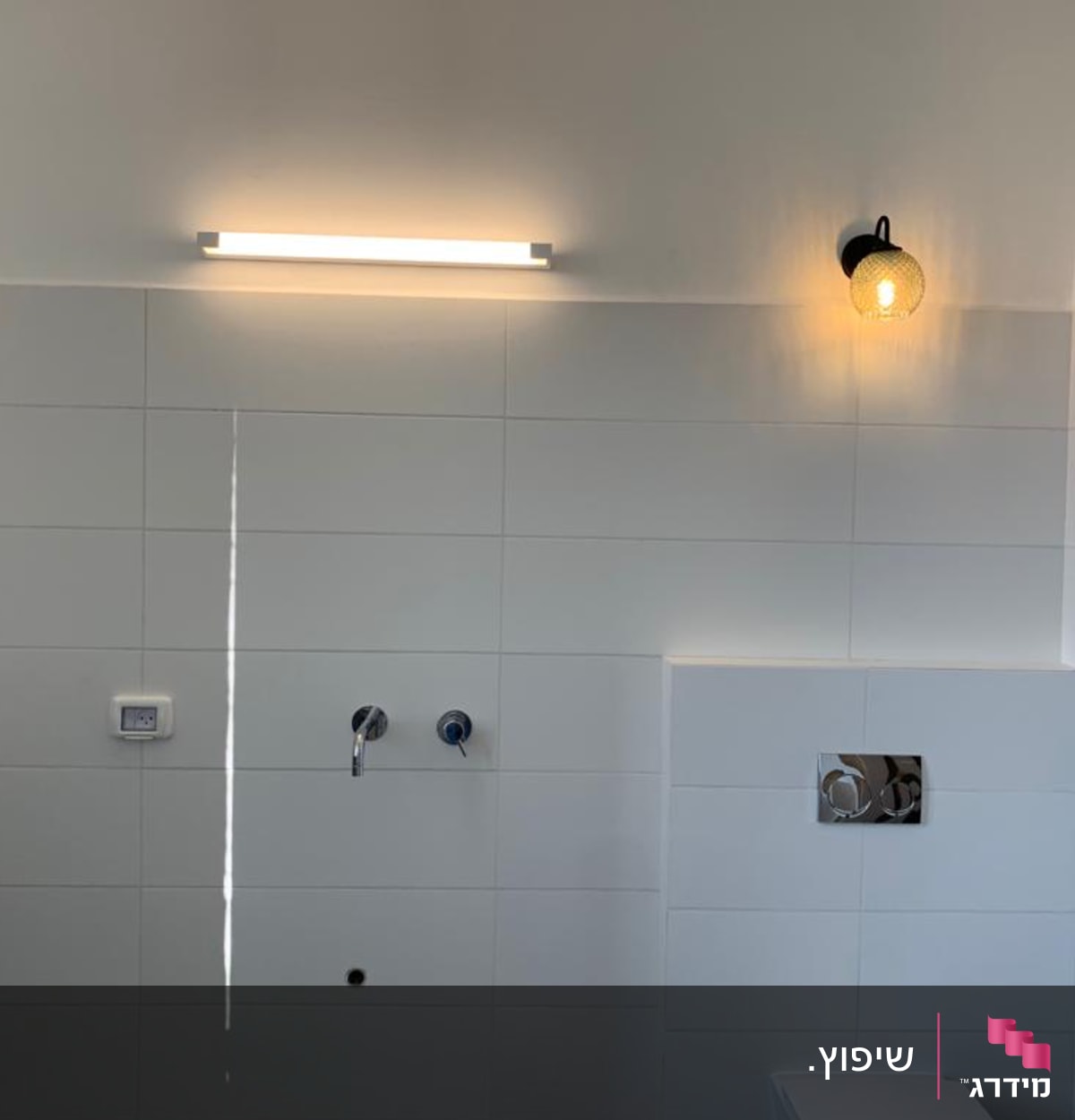 קיר אריחים לבנים עם גופי תאורה וברזים