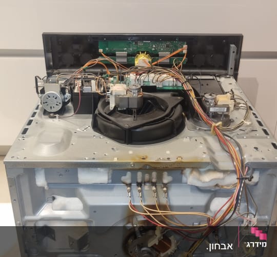 מכשיר חשמלי פתוח עם חוטים ורכיבים פנימיים גלויים