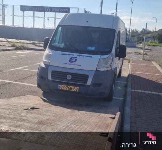 רכב גרר חונה ליד מדרכה בשטח פתוח