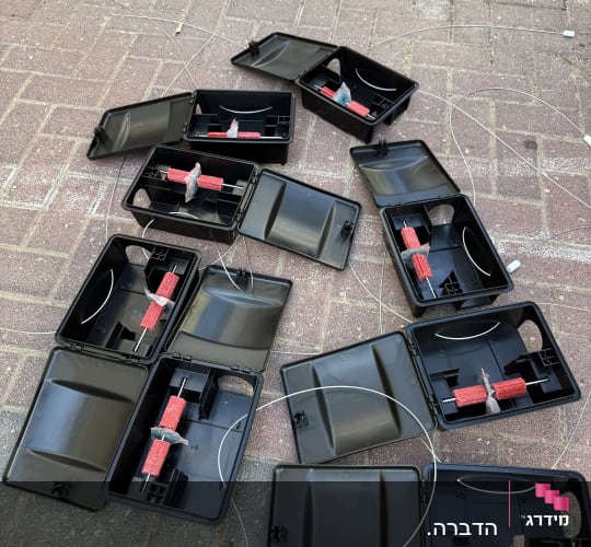 תיבות האכלה שחורות פתוחות עם בלוקים של פתיון רעל אדום להדברת מכרסמים