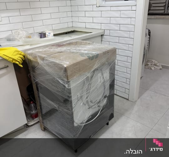 מכונת כביסה עטופה בניילון מוכנה להובלה