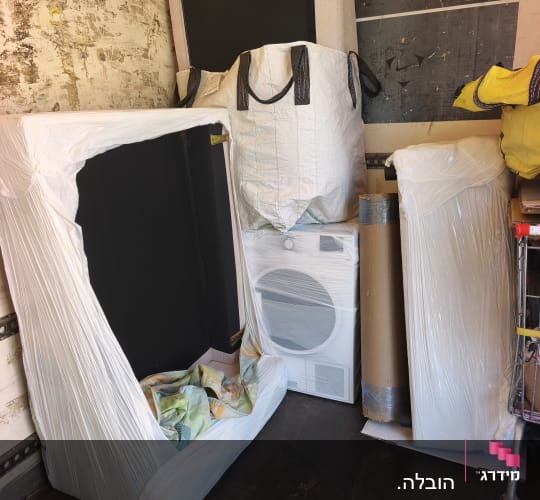 ציוד ורהיטי דירה עטופים בניילון נצמד בתוך משאית הובלה