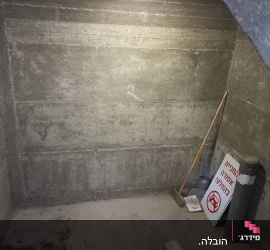 מטאטא על רצפת בטון ליד שלט איסור חניה