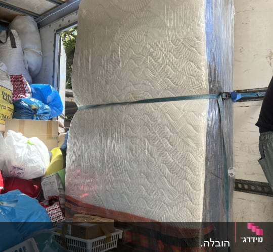 מזרן עטוף בניילון בתוך משאית הובלה עם חפצים נוספים
