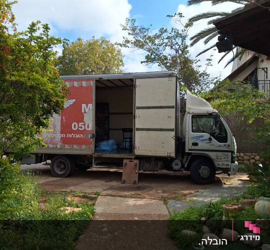 משאית הובלה חונה בחצר עם דלת פתוחה