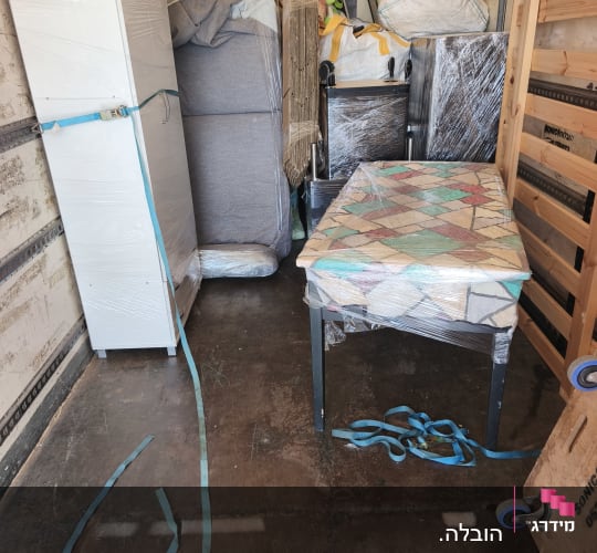 רהיטים וציוד ארוזים בתוך משאית הובלה