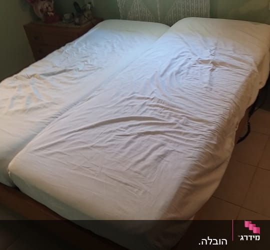 שתי מיטות יחיד מחוברות עם מצעים לבנים