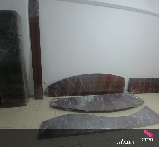 חלקי רהיטים עטופים בניילון מוכנים להובלה