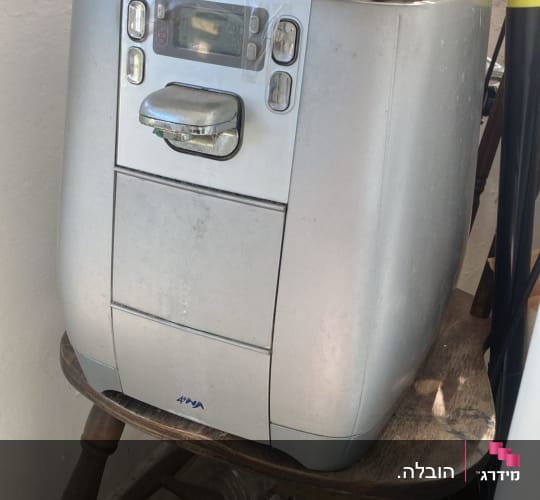 מכונה ישנה על כיסא עם קופסה וניירות