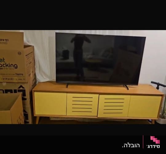 טלוויזיה על שידה עם קופסאות אריזה
