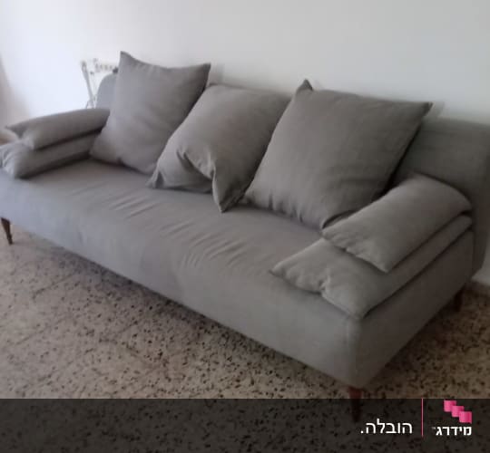 ספה אפורה עם כריות על רצפת טרצו