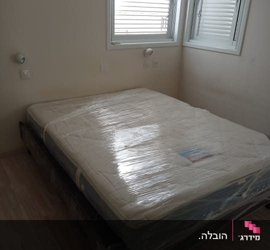 מזרן עטוף בניילון מוכן להובלה בחדר ריק