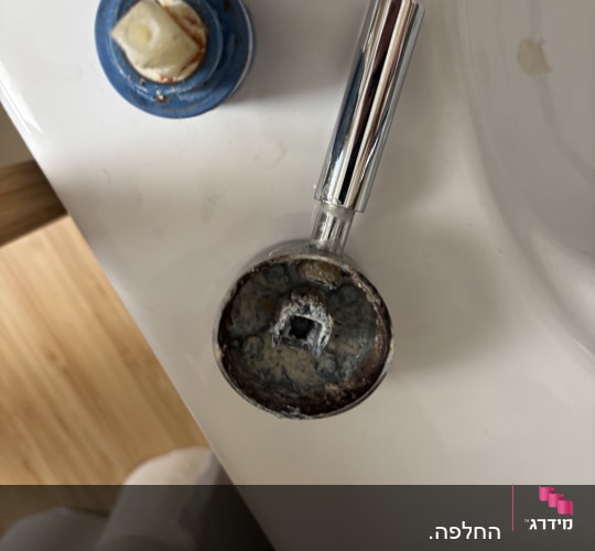 חלקי ברז מנותקים על כיור בחדר אמבטיה
