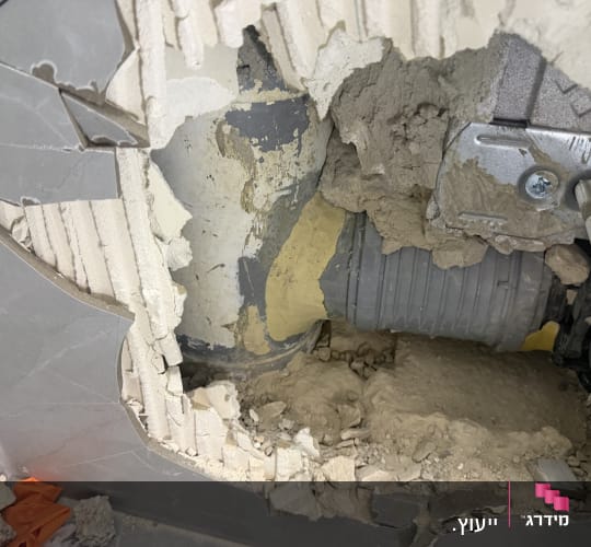תמונה של קיר שבור עם צינור חשוף