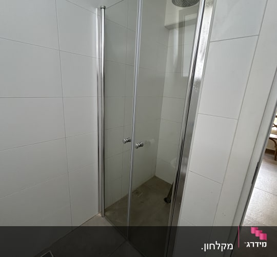 מקלחון עם דלתות זכוכית וראש מקלחת עגול