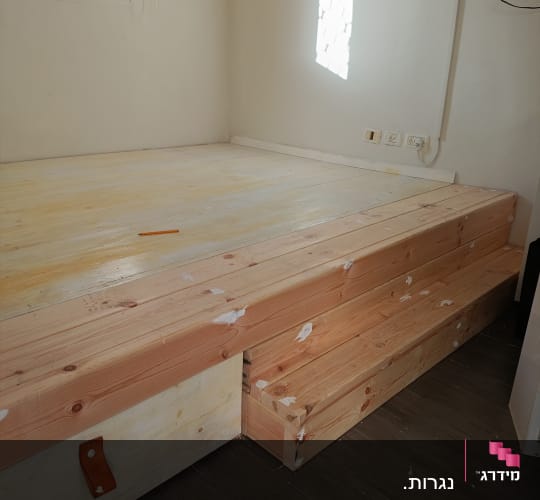 במה עץ עם מדרגות בחדר קטן