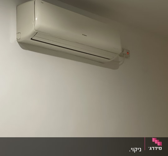 יחידת מיזוג אוויר מותקנת על קיר לבן