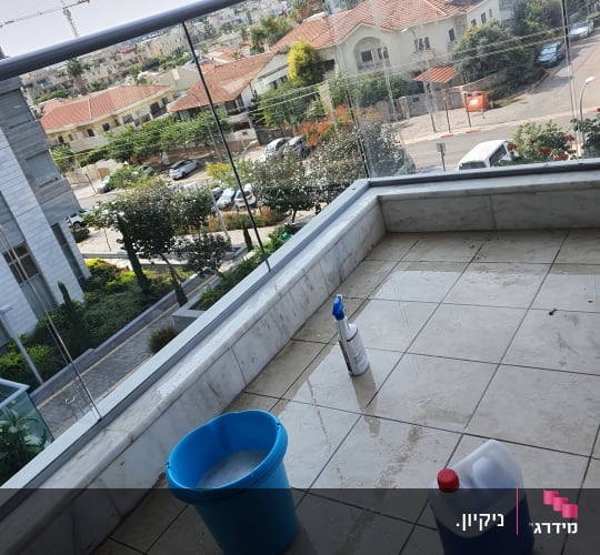 דלי כחול, בקבוק תרסיס, מיכל חומר ניקוי על מרפסת