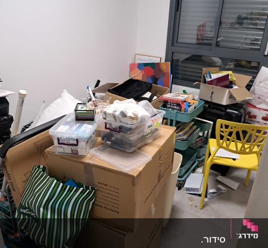 חדר מבולגן עם קופסאות וציוד לארגון בית