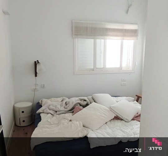 חדר שינה עם מיטה מבולגנת ומאוורר תקרה