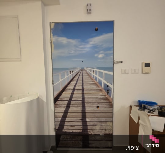 דלת עם תמונת נוף של גשר לים בחדר